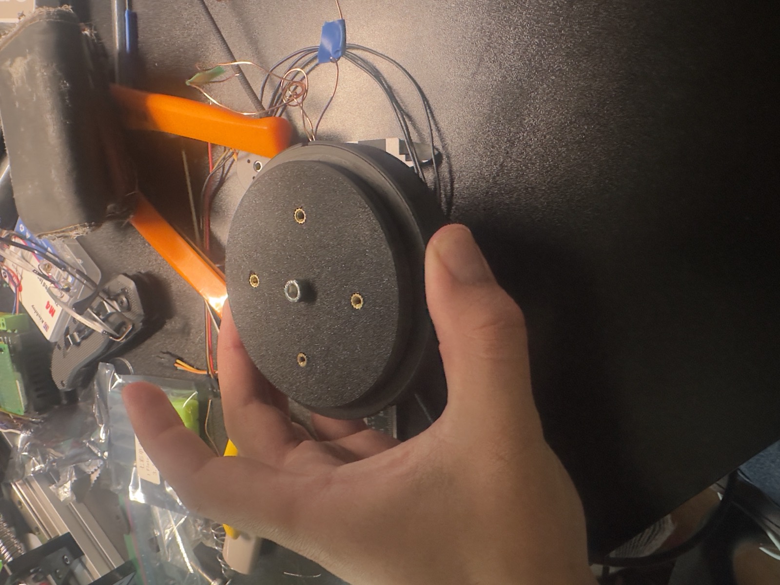 Hand holding a disc-shaped axial flux motor prototype